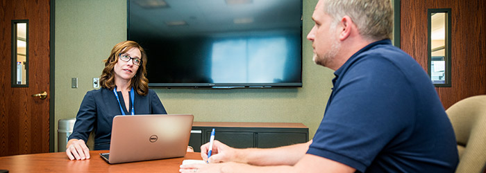 A Compassion staff member smiles and speaks to others at a table