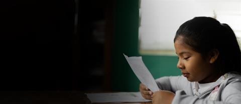 A girl in Bolivia reading her sponsor's letter