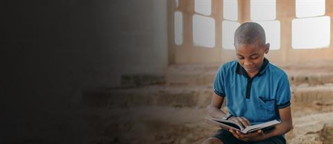 Boy sitting and reading the bible