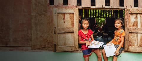 Girl smiling in front of a bamboo wall