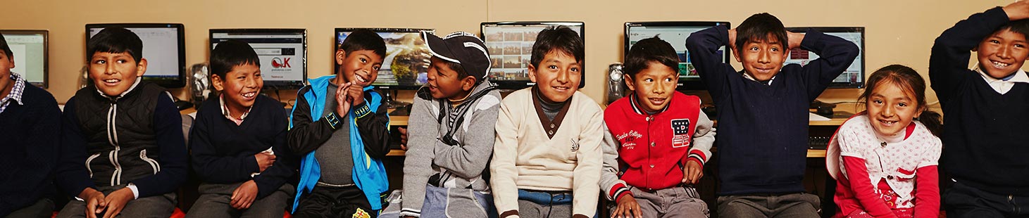 Compassion sponsored children sitting in front of computers at their child development center