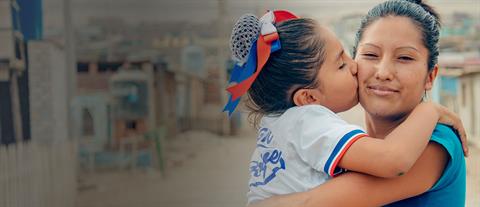 A girl kisses her mother on the cheek