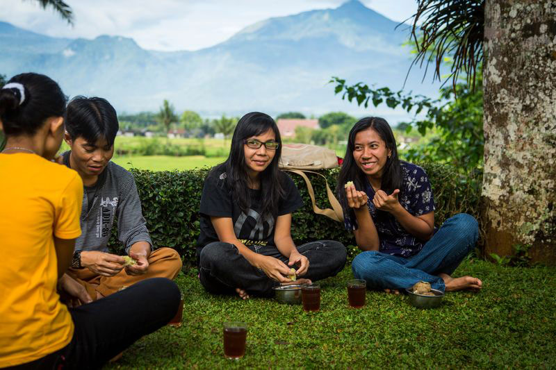 A group of teenagers sit outside