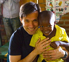 Jimmy Mellado smiles with a Compassion sponsored child