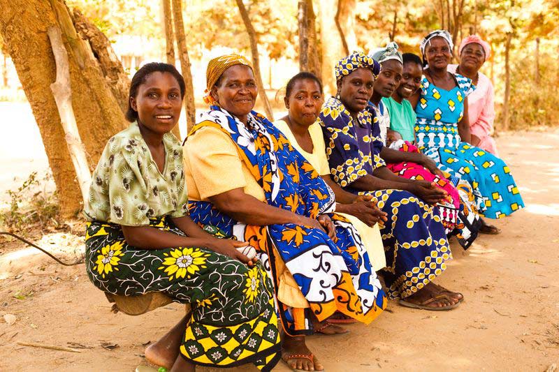 A group of women sit together and smile