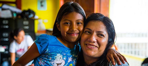 A young girl hugging a woman