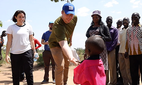 Nate Solder and wife Lexi greet a Compassion child