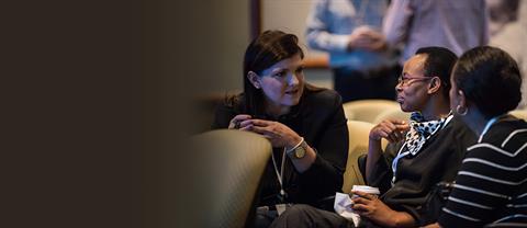 A group of Compassion employees talk at a table