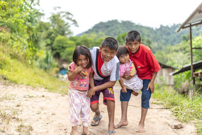 A family of children smiling and hugging each other