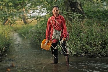 Oosami stands in a river