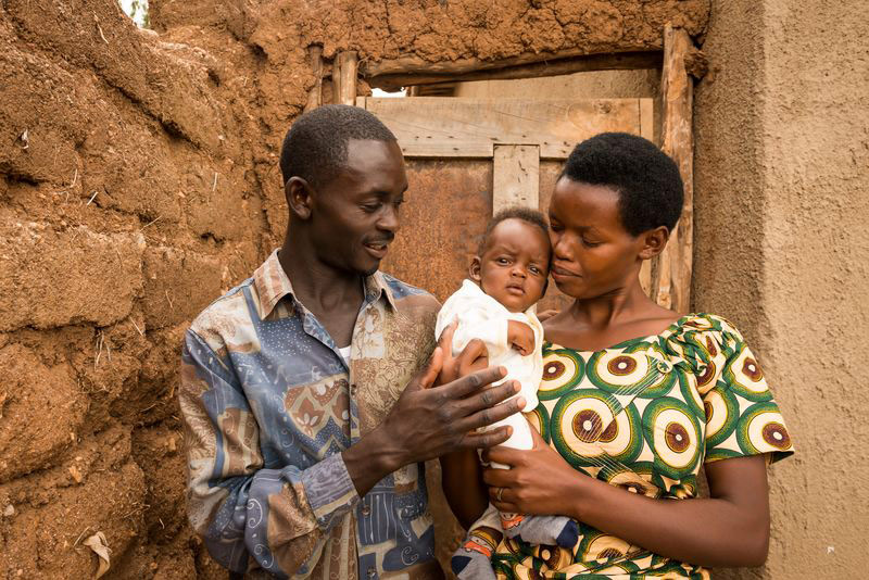 A mother and father hold their baby