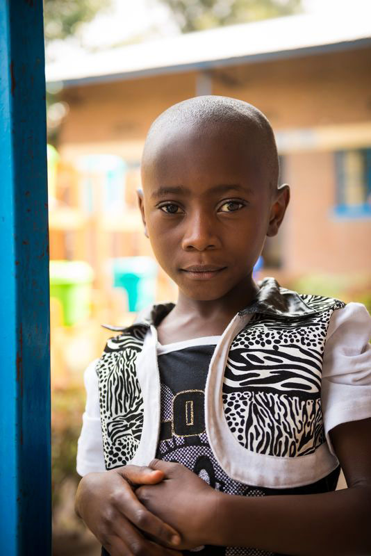 A girl looks in the window of her child development center