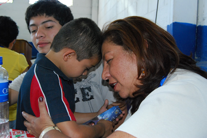 a child and adult touch their foreheads together in prayer