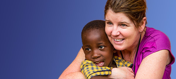 a woman sponsor hugs her sponsored child