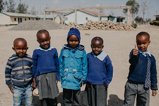 Several smiling children standing next to one another