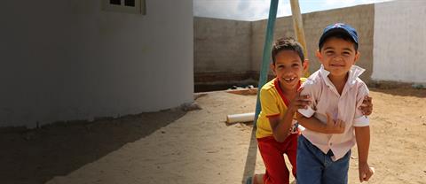 Two boys smile on a playground