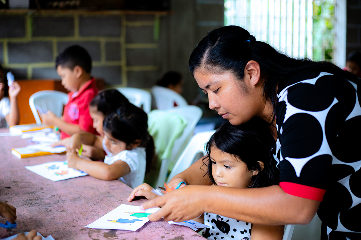 lady helps children write letters