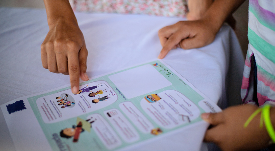 hands holding and pointing to letter