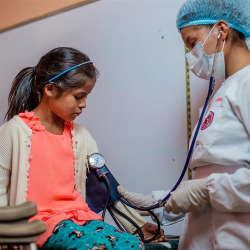 a child has her blood pressure taken by a doctor.