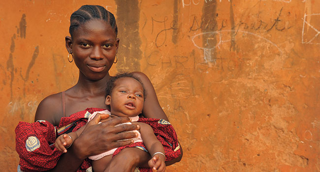 A young mother holding her infant child