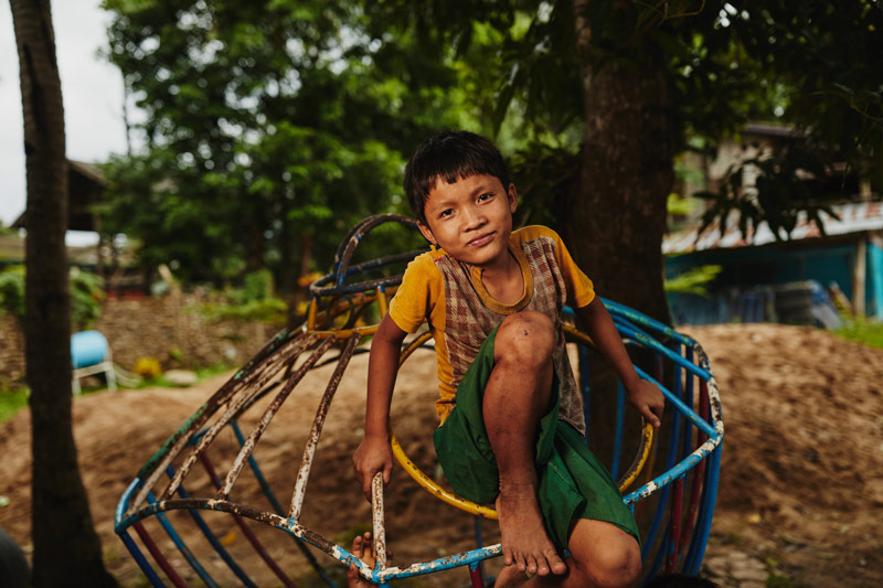 A child on a playground smiles