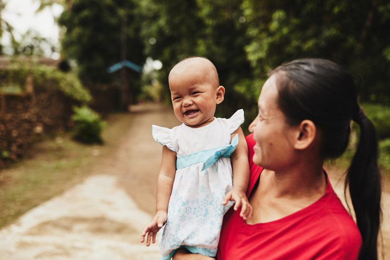 A mother holds a smiling baby