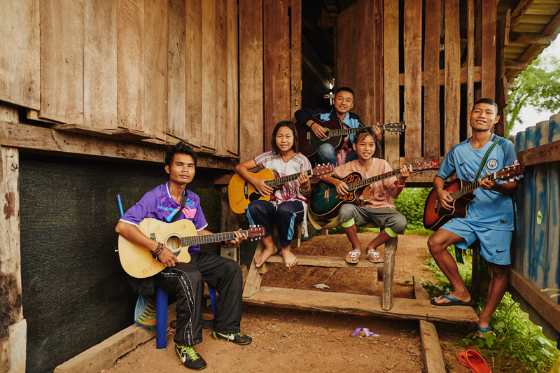 A group of teenagers learn how to play guitar