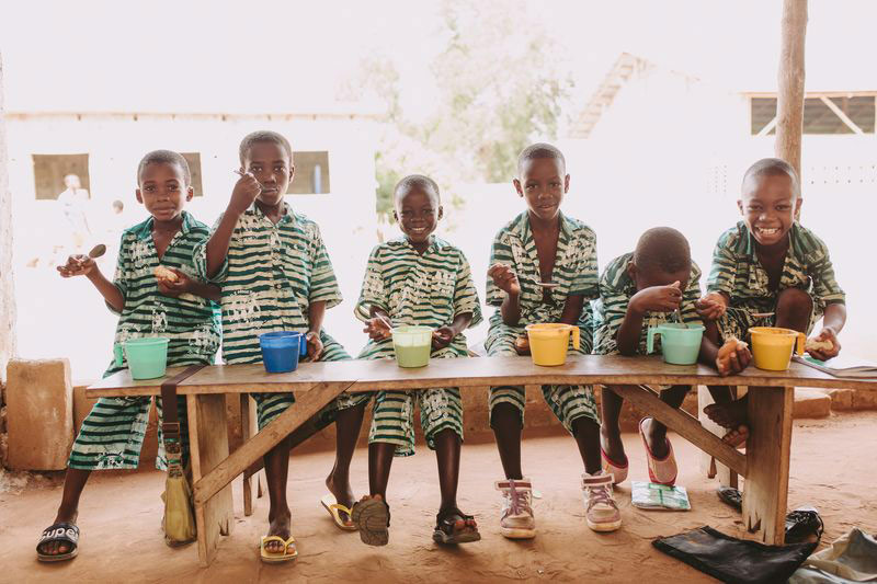 A group of boys in school uniform eating outside