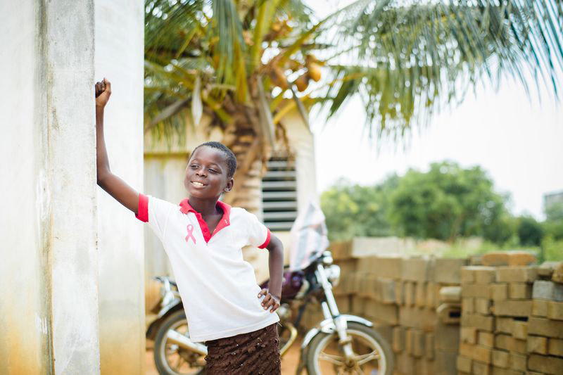 A girl standing outside in front of a bike