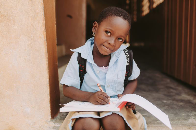 A young girl sits and colors