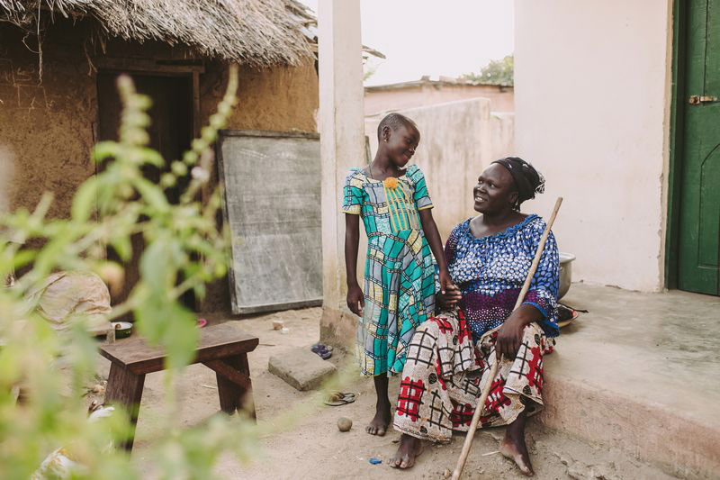 A girl holds hands with her grandmother