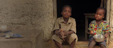 Two children sit in an open doorway