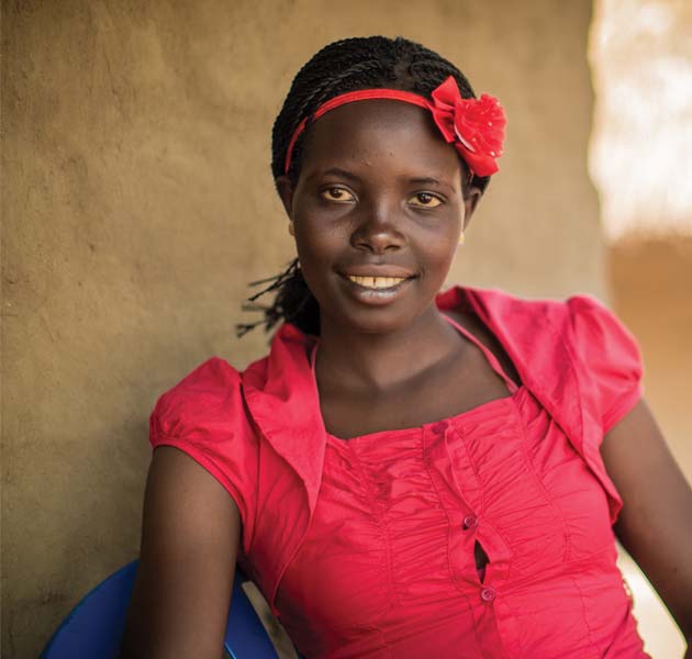 A teen girl wearing a red shirt and headband sitting outside