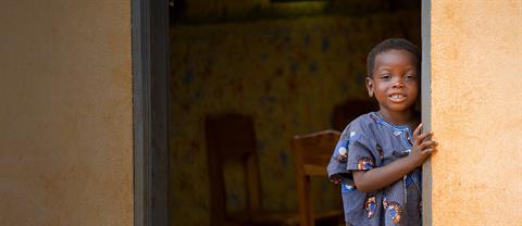 a boy stands in a doorway