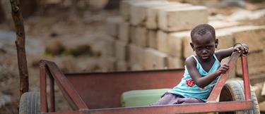 A young girl sitting alone on a trailer