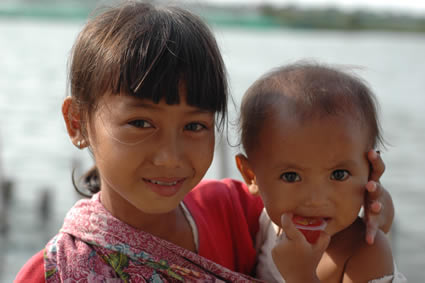 a young girl holding an infant