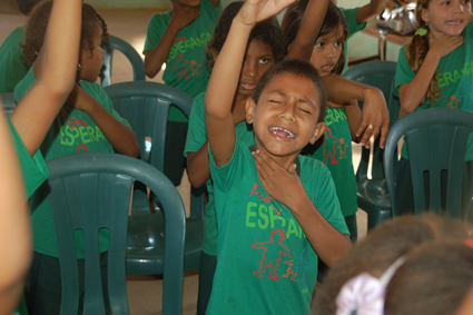 a boy holds one arm above his head in prayer