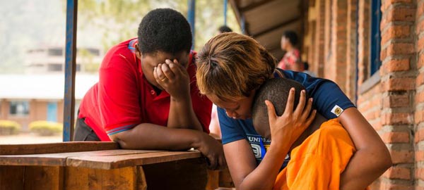 Sponsor embracing and praying for young boy