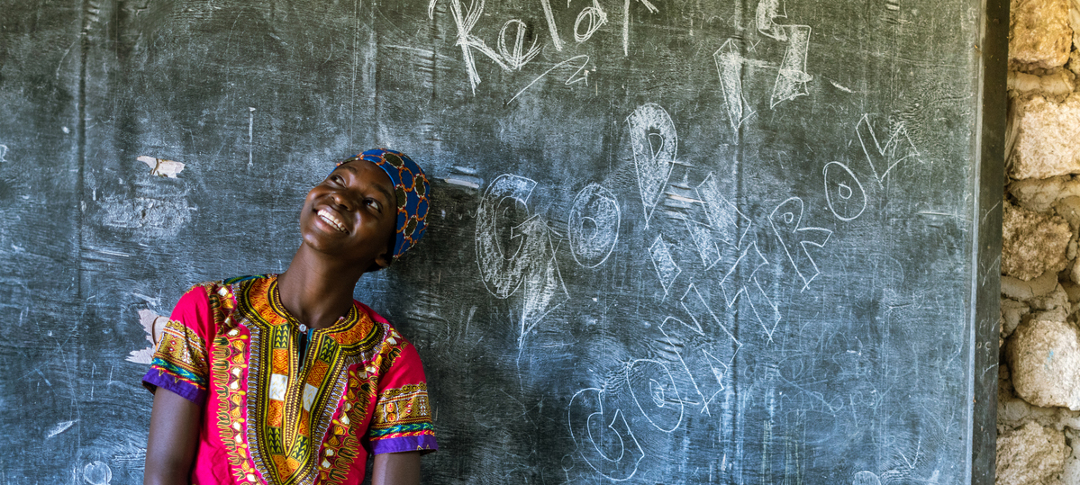 Young woman in front of chalkboard that says God is in control