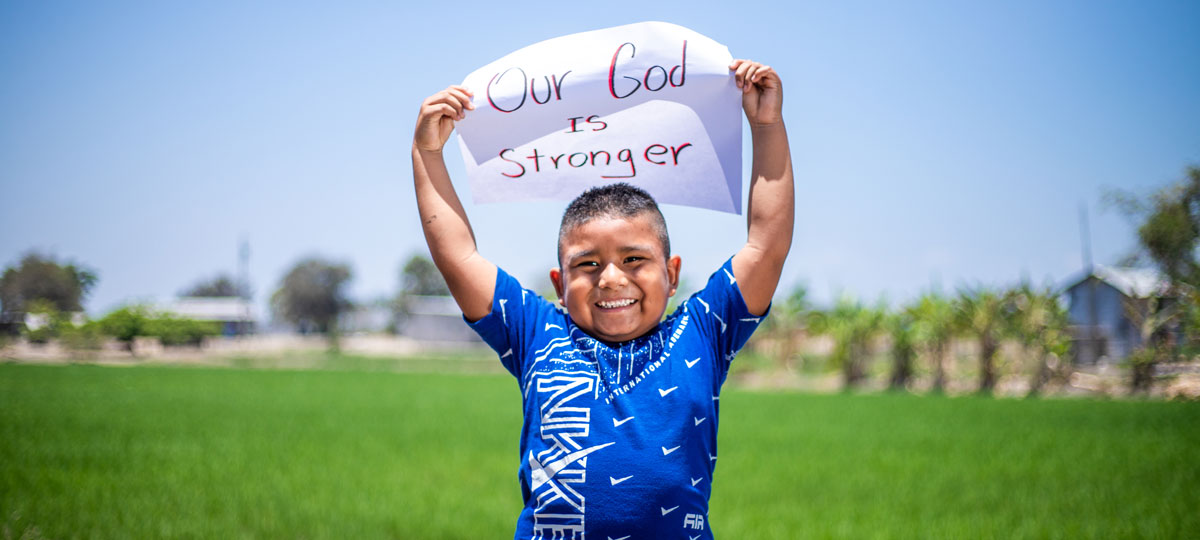 Young boy holding up sign