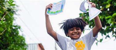 A young happy boy holds up letters