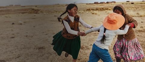 Three children playing ring around the rosie