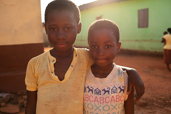 Two children outside hugging