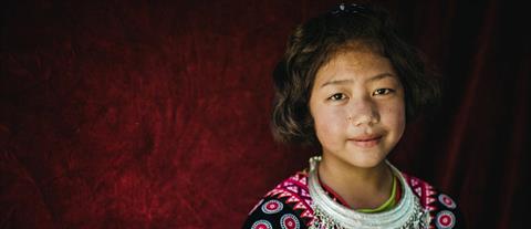 A young girl in front of a red background