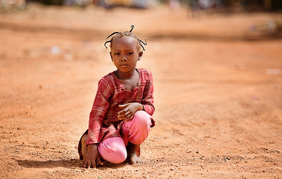 A girl in red kneels on one knee