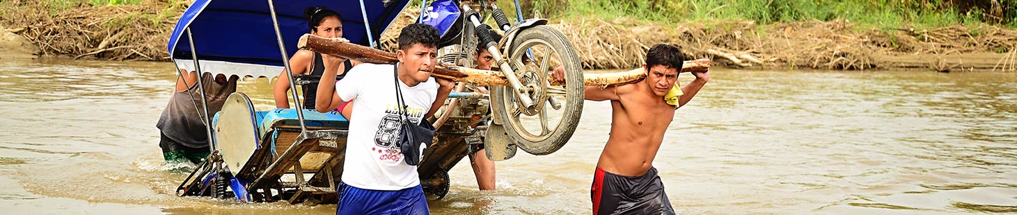 People lugging a bicycle through a flood