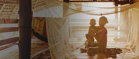 A mother and baby underneath a malaria mosquito bed net