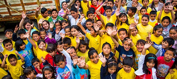 A large group of children waving hello