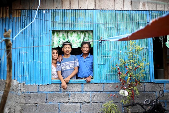 A family of three seen standing in a window