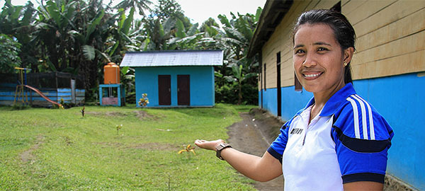 A woman directs attention to a hygienic toilet facility